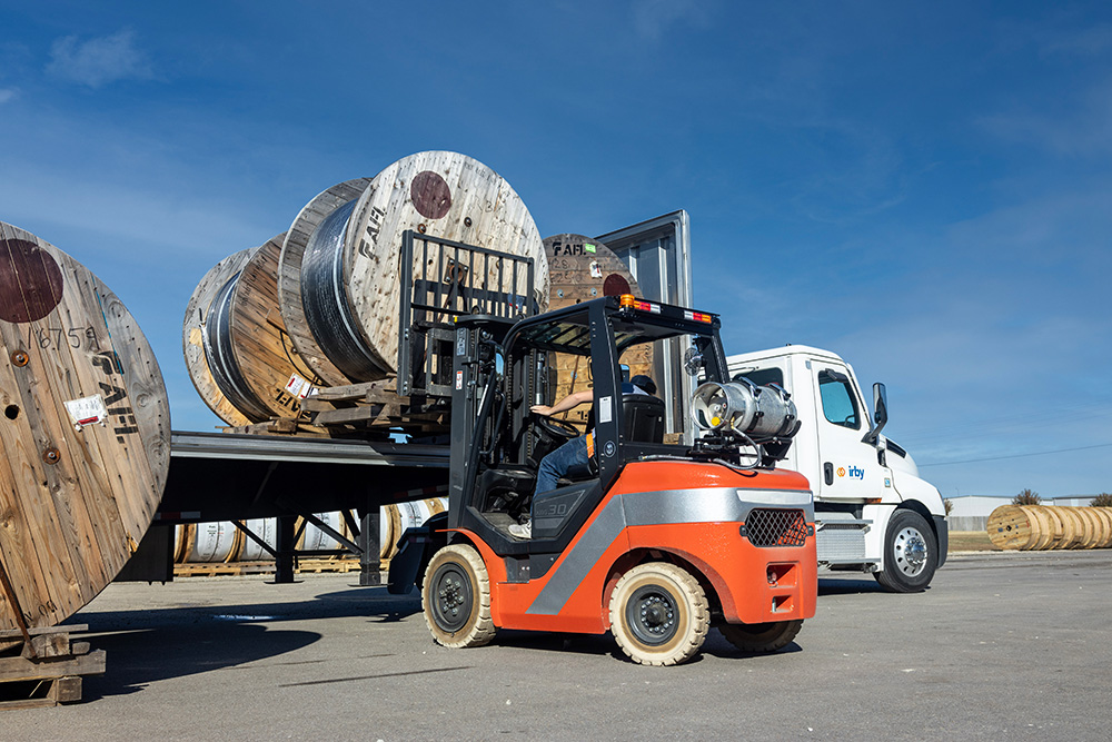 forklift loading broadband cable onto irby semi truck